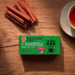 3 Ballerina cinnamon flavor herbal tea box with brewed tea cup and cinnamon sticks on wooden surface