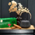 3 Ballerina cinnamon herbal tea box with cast iron teapot and cinnamon sticks on a wooden tray